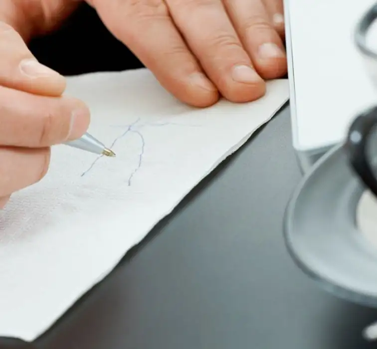 Technology | Laminar | WiFi-in-a-Box – The Napkin Idea | Man writing on a napkin