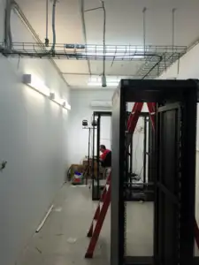 man setting up more fibre and power to the racks